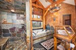 The luxurious master ensuite walk-in shower features custom stone work.